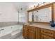 This main bathroom is equipped with a soaking tub, wooden vanity, and a large mirror at 2550 Columbia Crossing Ct, Decatur, GA 30034