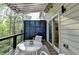 Cozy balcony featuring a sliding glass door, awning, string lights, and views of surrounding trees at 2685 Maple Park Pl # 27, Cumming, GA 30041