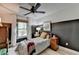 Cozy bedroom with a striped bedspread, a dark accent wall, modern decor, and a ceiling fan for comfortable living at 2685 Maple Park Pl # 27, Cumming, GA 30041
