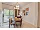 Cozy dining area with wood table, stylish chairs, modern light fixture, and sliding door with natural light at 2685 Maple Park Pl # 27, Cumming, GA 30041