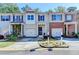 Townhome exterior showcasing a well-kept lawn, two-car garage, and tasteful landscaping at 2685 Maple Park Pl # 27, Cumming, GA 30041