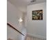 Light and airy hallway with wooden stairs, an art print, a modern sconce, and neutral decor, creating an inviting space at 2685 Maple Park Pl # 27, Cumming, GA 30041