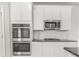 Gourmet kitchen features stainless appliances, double ovens, granite counters, and white subway tile backsplash at 288 Overlook Rd, Covington, GA 30014