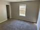 Comfortable bedroom featuring neutral walls, plush carpet, and natural light from a window at 5719 Star Flower Dr, Ellenwood, GA 30294