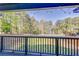 View of backyard and lake from deck, with a wood railing and trees in the background at 1762 Green Rd, Buford, GA 30518
