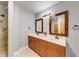 Well-lit bathroom with double vanity, framed mirrors, and walk-in shower at 1762 Green Rd, Buford, GA 30518