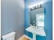Powder room with pedestal sink, framed mirror, and modern lighting against two-tone blue walls at 1762 Green Rd, Buford, GA 30518