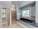 Bathroom featuring a black soaking tub and tiled walk-in shower, illuminated by natural light at 1762 Green Rd, Buford, GA 30518