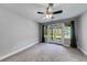 Bright bedroom with plush carpeting, French doors, and a ceiling fan at 1762 Green Rd, Buford, GA 30518