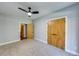 This bedroom features neutral paint, carpet flooring, a ceiling fan, and a closet at 1762 Green Rd, Buford, GA 30518