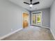 This bedroom features neutral paint, carpet flooring, a ceiling fan, and French doors to the exterior at 1762 Green Rd, Buford, GA 30518