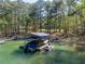 Covered boat dock and jet ski lift on a serene, tree-lined lake at 1762 Green Rd, Buford, GA 30518