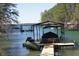 View of a private covered boat dock on a serene, wooded waterfront property at 1762 Green Rd, Buford, GA 30518