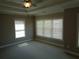 Spacious bedroom featuring large windows, tray ceiling, and neutral carpeting at 1835 Morning Star Ln, Tucker, GA 30084
