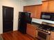 A modern kitchen with wood cabinets, black appliances, and hardwood floors for a sleek design at 1835 Morning Star Ln, Tucker, GA 30084