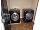 A laundry room featuring black washer and dryer appliances on a tiled floor at 1835 Morning Star Ln, Tucker, GA 30084