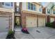 Inviting townhome exterior with brick accents, a two-car garage, and a neatly landscaped entrance at 2840 Smith Ridge Trce, Peachtree Corners, GA 30071