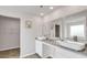 Bright bathroom featuring double sinks, granite counters, and an adjacent walk-in closet at 668 Egrets Landing #64, Covington, GA 30014