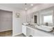 Bright bathroom featuring double sinks, granite counters, and an adjacent walk-in closet at 668 Egrets Landing #64, Covington, GA 30014
