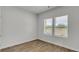 Well-lit bedroom featuring wood-look floors and two windows with natural light at 668 Egrets Landing #64, Covington, GA 30014