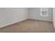 Spacious bedroom features neutral carpet and a bright window at 668 Egrets Landing #64, Covington, GA 30014