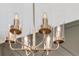 Close-up of an elegant contemporary chandelier with gold hardware and cylinder glass shades at 668 Egrets Landing #64, Covington, GA 30014