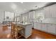 Modern kitchen leading to dining and living spaces, featuring a center island and hardwood floors at 1888 Fox Chapel Se Dr, Smyrna, GA 30080