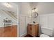 Stylish half-bathroom with wood-look vanity, round mirror, and modern lighting at 1888 Fox Chapel Se Dr, Smyrna, GA 30080