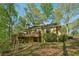 Charming single-story home surrounded by lush trees, showcasing a wooden deck and beautiful natural setting at 230 Oakmere Dr, Alpharetta, GA 30009