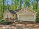Charming home exterior with a wooden porch and a two-car garage surrounded by mature trees at 230 Oakmere Dr, Alpharetta, GA 30009