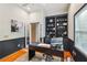 A well-lit home office features a built-in bookshelf, hardwood floors, and a large window at 230 Oakmere Dr, Alpharetta, GA 30009