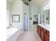 Bright bathroom with a soaking tub, dual sinks, and access to the walk-in closet and bedroom at 5095 Hamby Hollow Ln, Cumming, GA 30028