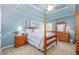Charming bedroom boasts a four-poster bed, soft blue walls, and plush carpet at 5095 Hamby Hollow Ln, Cumming, GA 30028