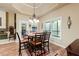 Inviting dining area with wood floors, chandelier lighting, and large windows offering ample natural light at 5095 Hamby Hollow Ln, Cumming, GA 30028
