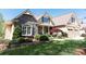 Beautiful home featuring stone accents, a covered porch, lush landscaping, and an attached two-car garage at 5095 Hamby Hollow Ln, Cumming, GA 30028