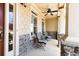 Inviting front porch with stone accents, comfortable seating, and a ceiling fan for relaxing outdoors at 5095 Hamby Hollow Ln, Cumming, GA 30028