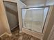 Bathroom featuring tub-shower combo with sliding door and tile surround at 6718 Roscommon Dr, Austell, GA 30168