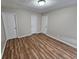 Bedroom with hard wood flooring, three doors, and a ceiling light at 6718 Roscommon Dr, Austell, GA 30168