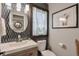 Stylish powder room with a modern vanity, decorative mirror, and eye-catching accent wall at 1153 Haven Brook Ln, Brookhaven, GA 30319