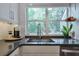 A close up of the kitchen sink and counter top with subway tile back splash and natural light at 1153 Haven Brook Ln, Brookhaven, GA 30319