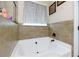 Bathroom showing a corner tub with decorative tile and window at 257 Ironwood Dr, Stockbridge, GA 30281