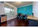 Bright workspace with hardwood floors, a modern accent wall, and large window at 257 Ironwood Dr, Stockbridge, GA 30281