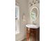 Bathroom vanity with dark wood cabinet and white basin sink under a stylish oval mirror at 375 Highland Ne Ave # 508, Atlanta, GA 30312