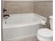 A simple white bath tub and commode with tiled walls at 375 Highland Ne Ave # 508, Atlanta, GA 30312