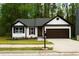 Charming home featuring a well-manicured lawn, brick accents, and a two-car garage at 4907 Windsor Downs Dr, Decatur, GA 30035