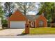Charming one-story brick home featuring an attached garage, well-maintained lawn, and inviting front entrance at 1960 Banks Way, Atlanta, GA 30349