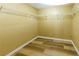 Empty walk-in closet with wire shelving, providing ample storage space, and wood-look laminate flooring at 1960 Banks Way, Atlanta, GA 30349