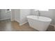 Freestanding soaking tub in a modern bathroom with tile floors and neutral paint at 342 Overlook Rd, Covington, GA 30014
