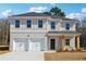 Two-story home featuring a white brick facade, a two-car garage, and a covered front porch with natural wood pillars at 342 Overlook Rd, Covington, GA 30014