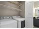 This is a laundry room that includes a washing machine, dryer, and white metal shelving at 735 Ponce De Leon Pl Ne Unit 1, Atlanta, GA 30306